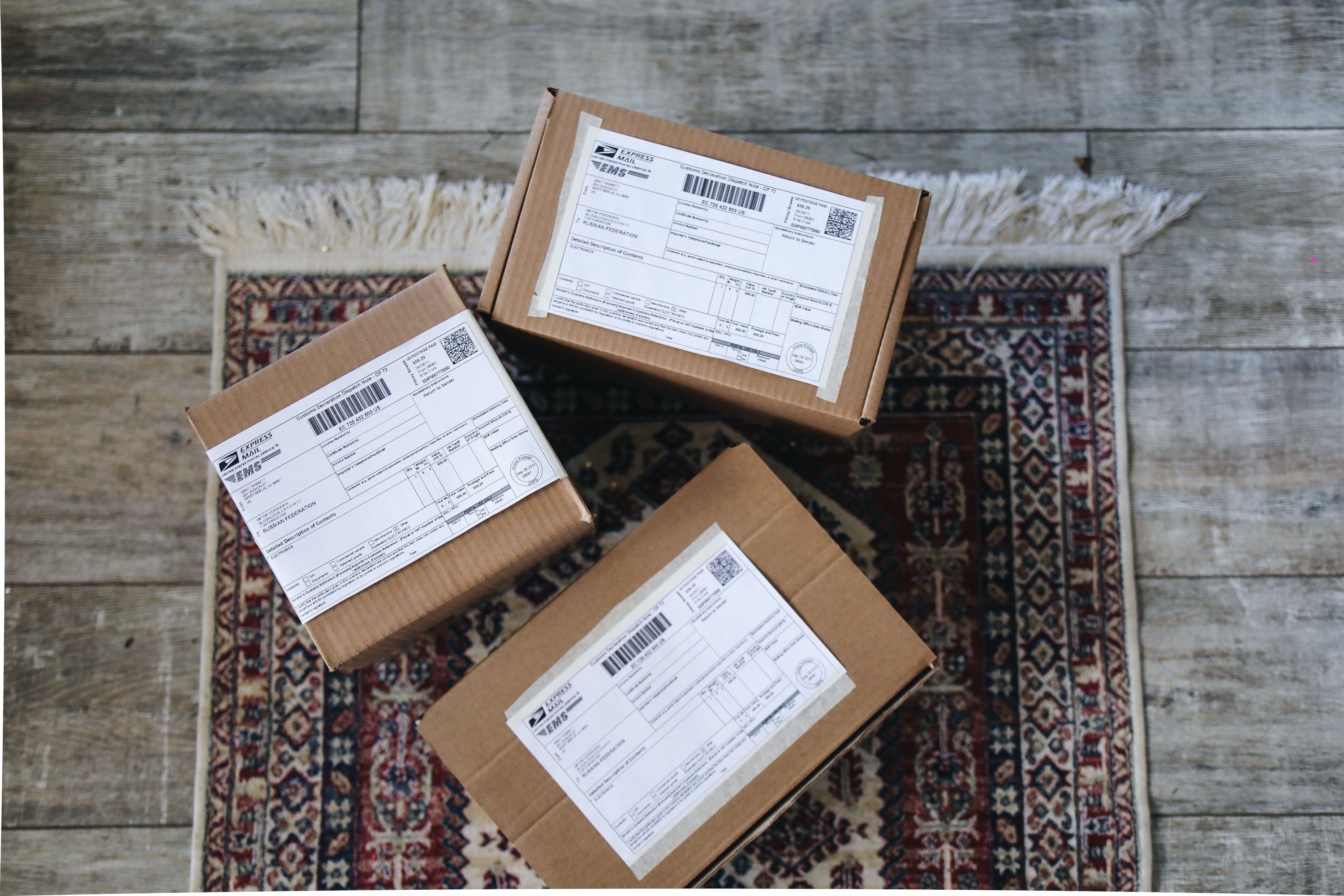 Three labeled parcels on the floor on a carpet