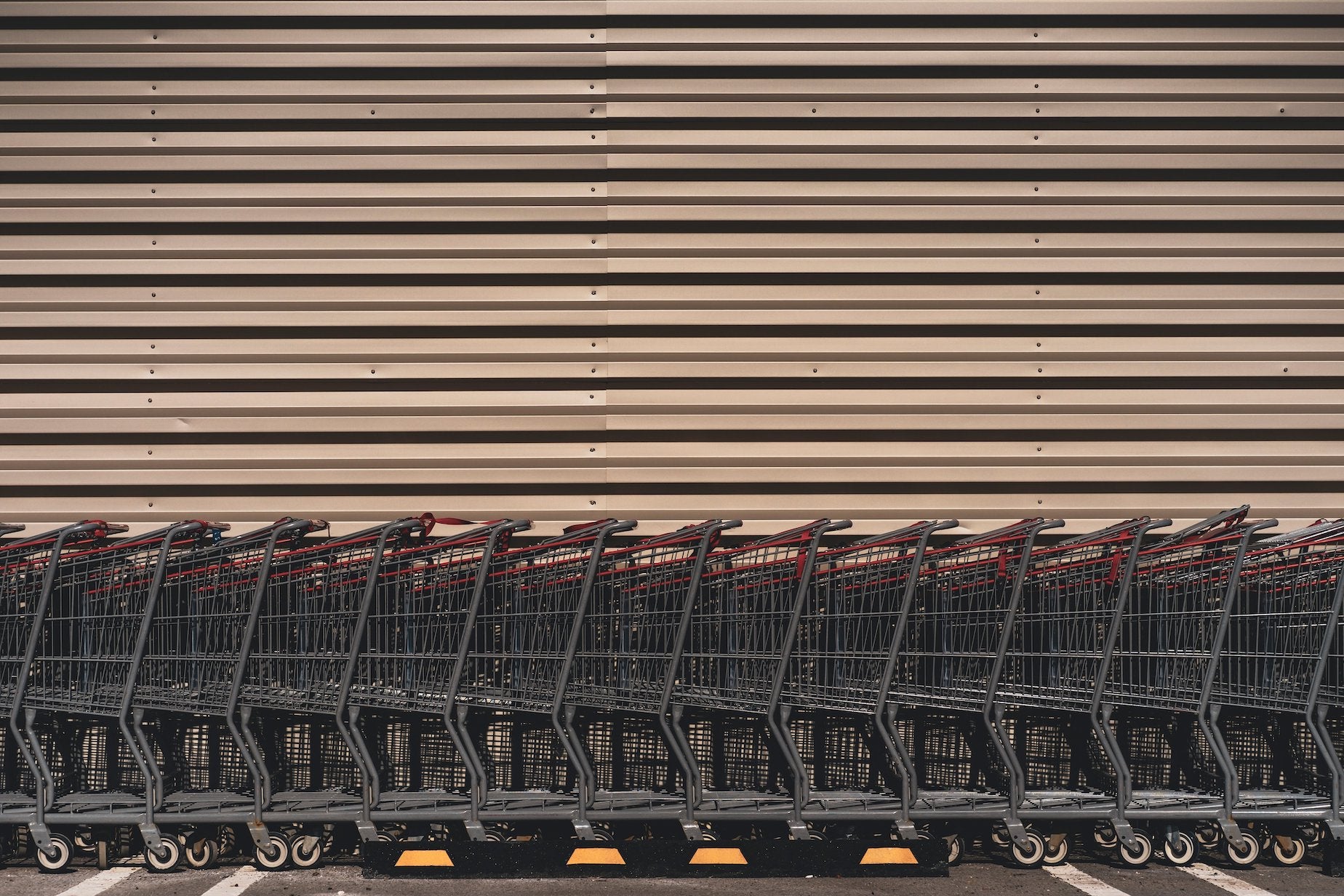 Shopping carts lined up in a straight line against a wall