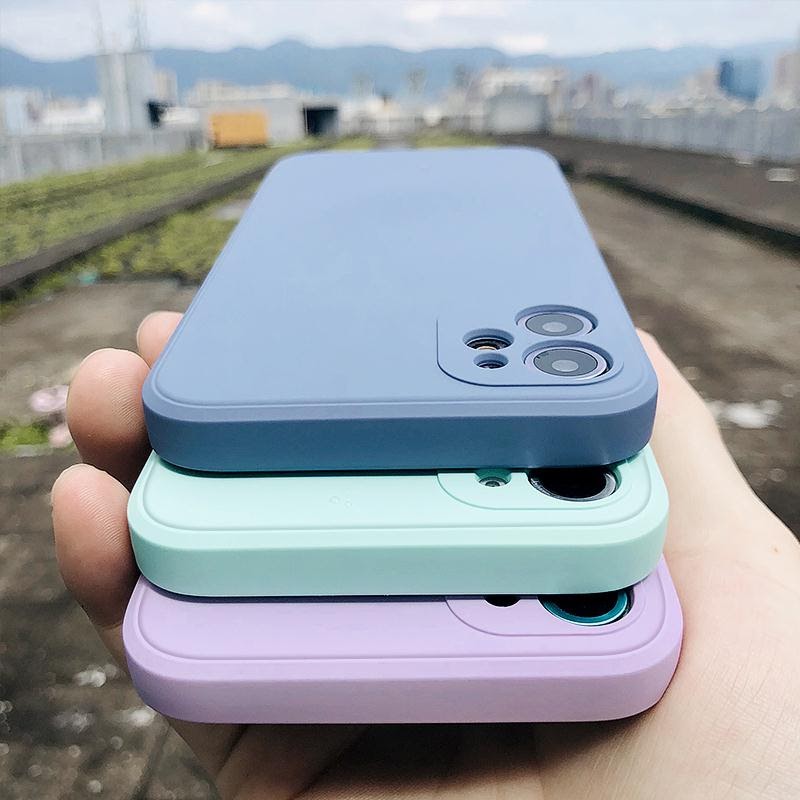 Three pastel-colored silicone phone cases stacked in a hand.