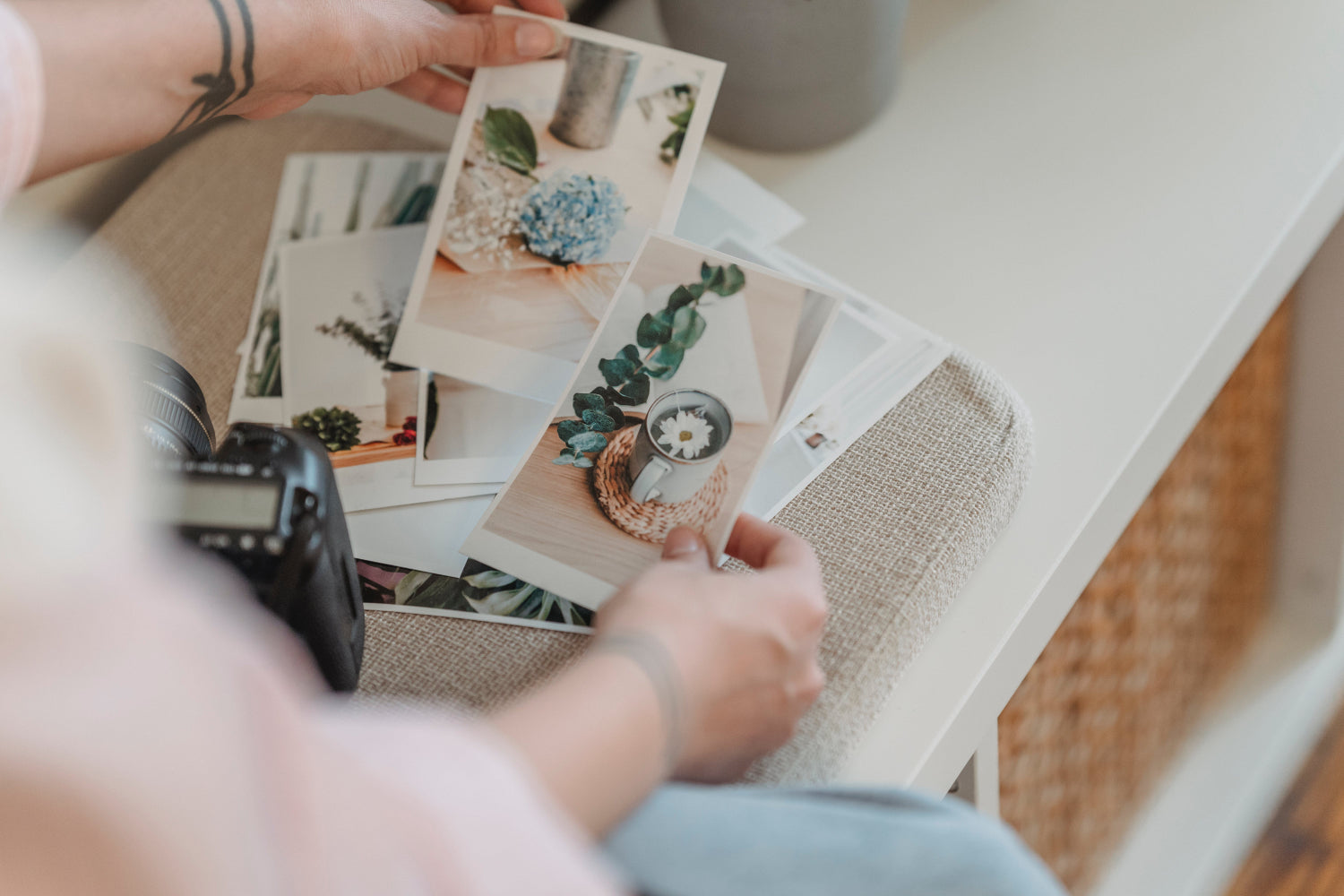 A person sorts a pile of printed photographs