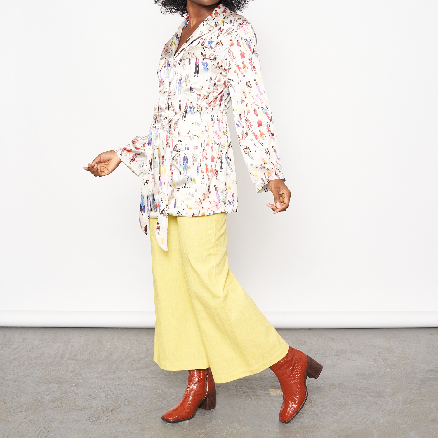 A model poses in a patterned top and yellow pants