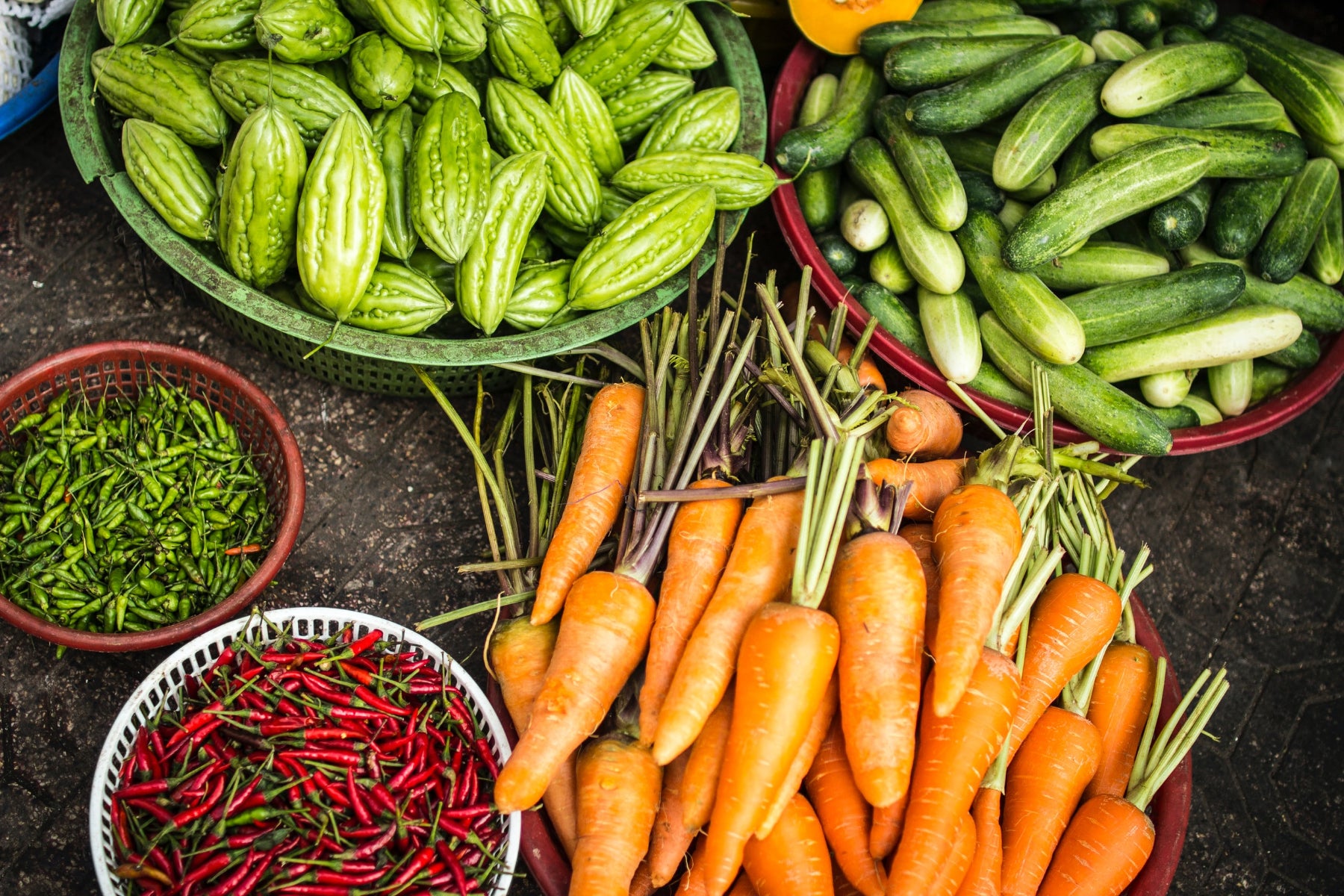 Array of vegetables and hot peppers in bowls on a table