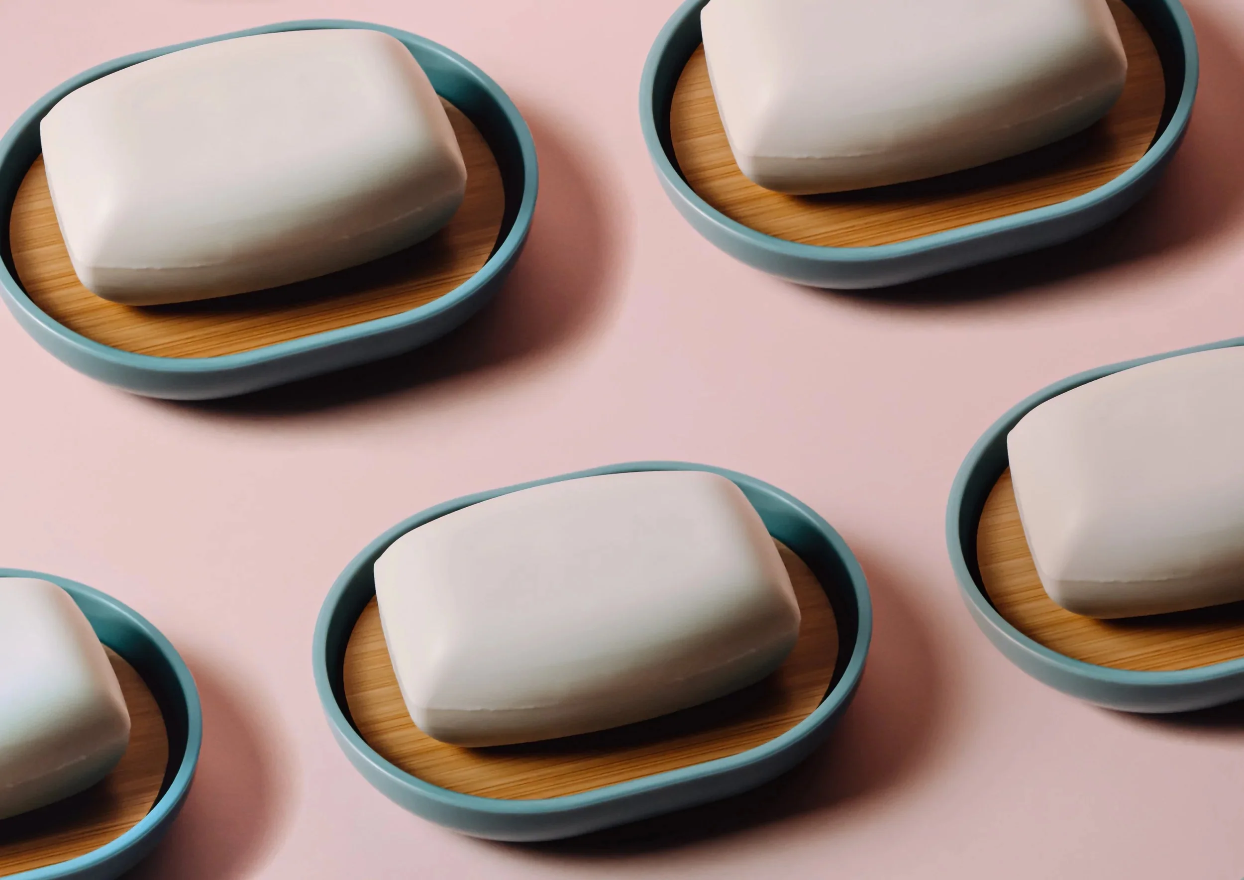 Bars of pink soap arranged on a flat pink surface