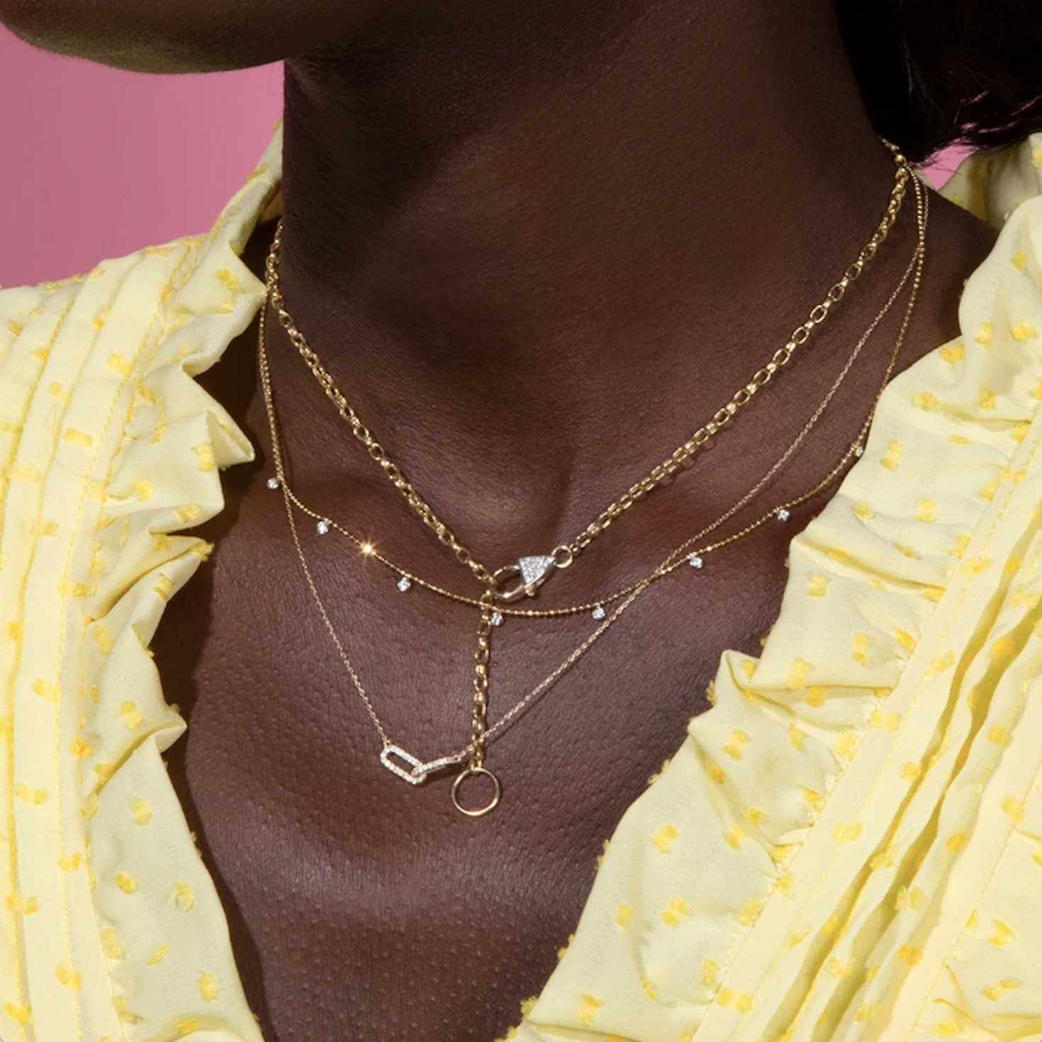 A closeup of a woman wearing three Stone and Strand necklaces