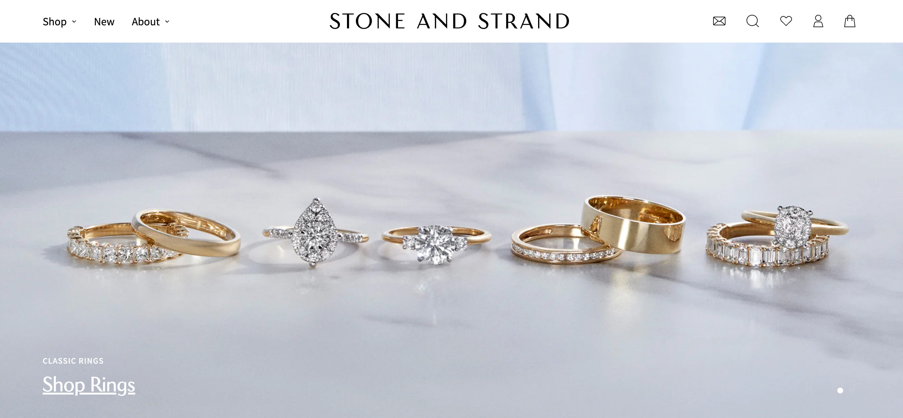 On Stone and Strand's homepage, various rings sit atop a white surface