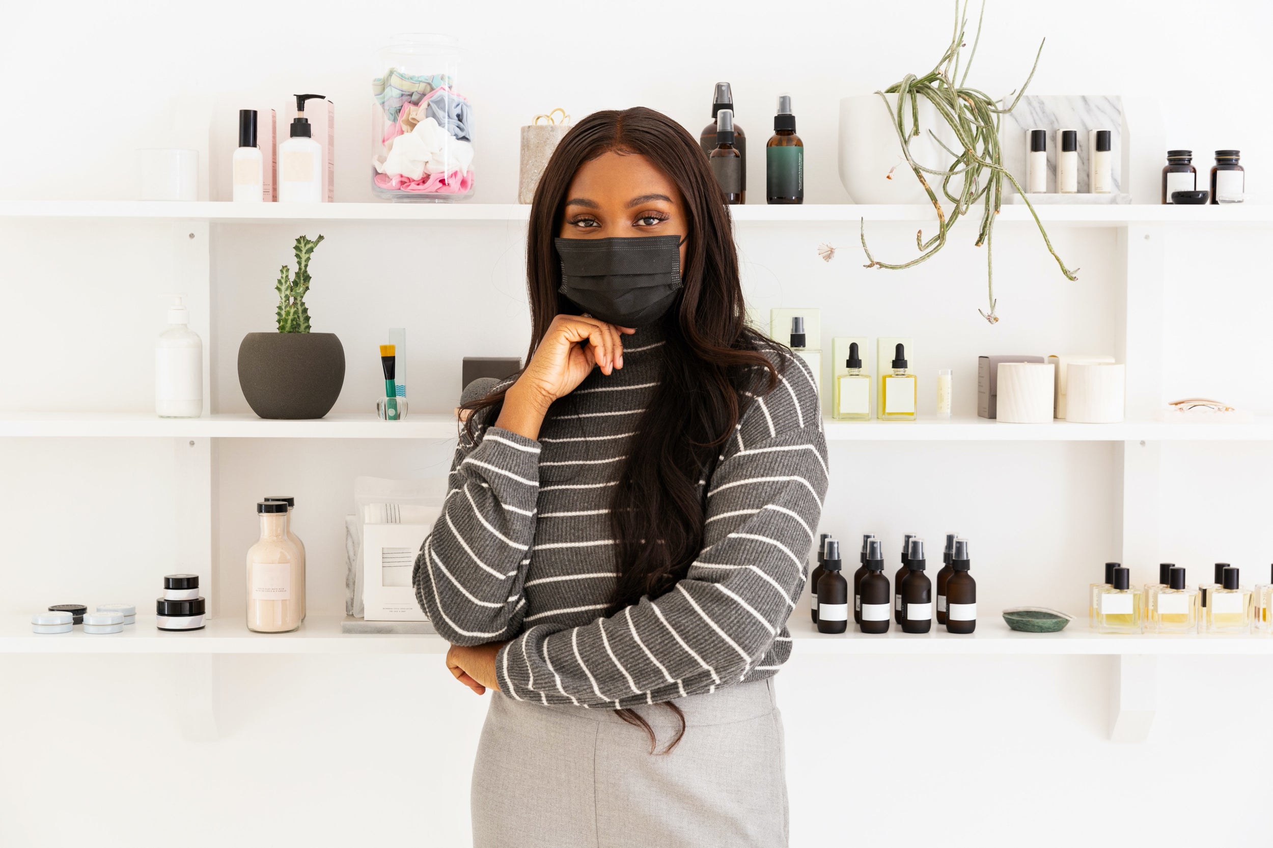 A woman in a face mask stands in front of a store display