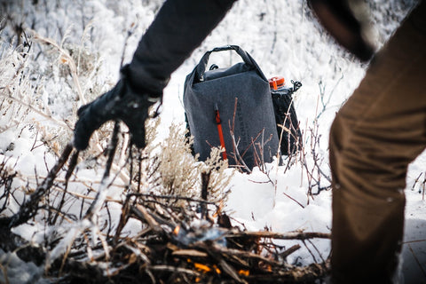 a person in the foreground frames a survival kit by uncharted