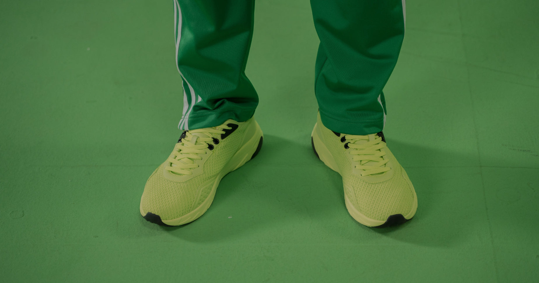 Crop of a person's legs and feet wearing green clothing