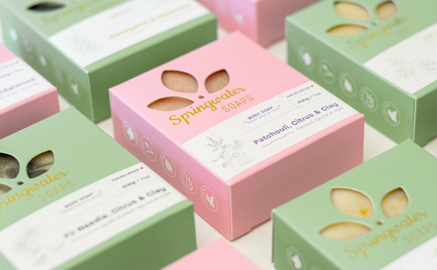 A flat lay of soap in mint and strawberry colored packaging