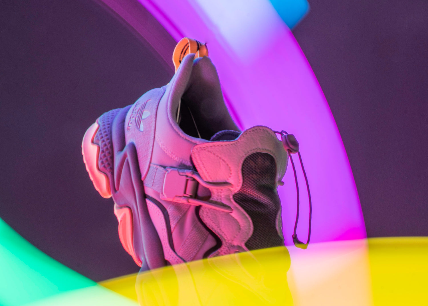 A sneaker bathed in colorful light patterns