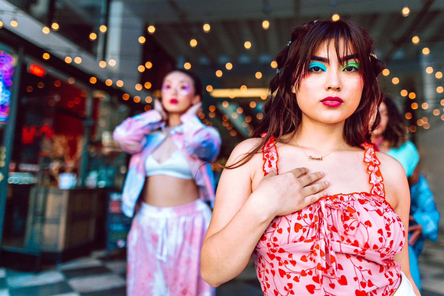 Two women dressed in vibrant clothing and makeup inside a retail store