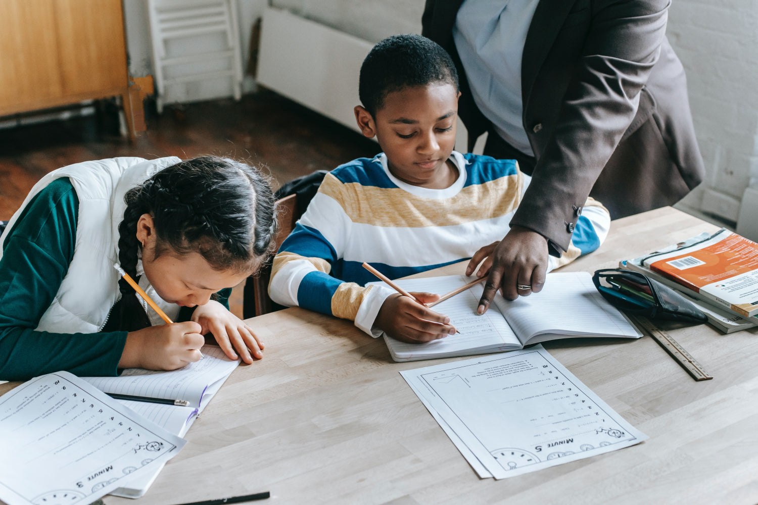 Small children get tutoring from an older person