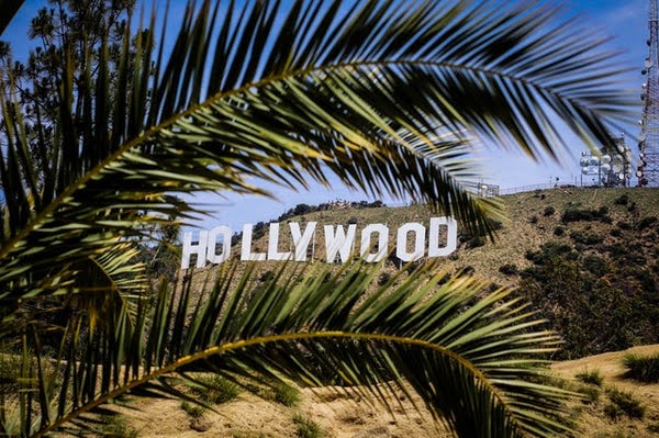 Image of Hollywood sign through palm trees.