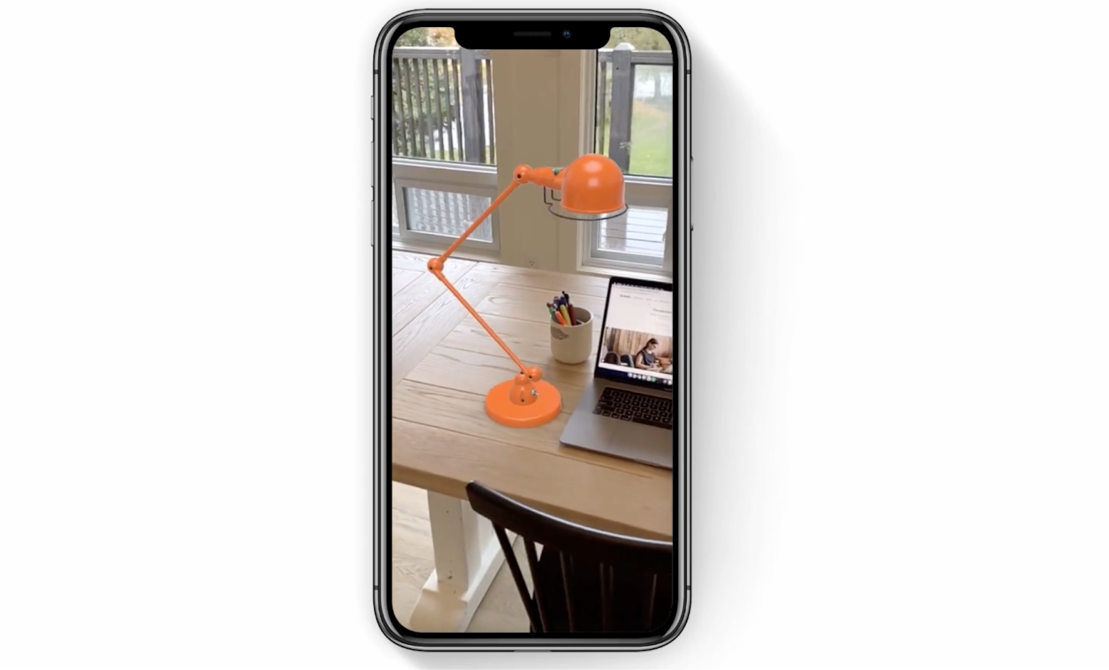 A cell phone screen showing an orange lamp sitting on a wooden table.