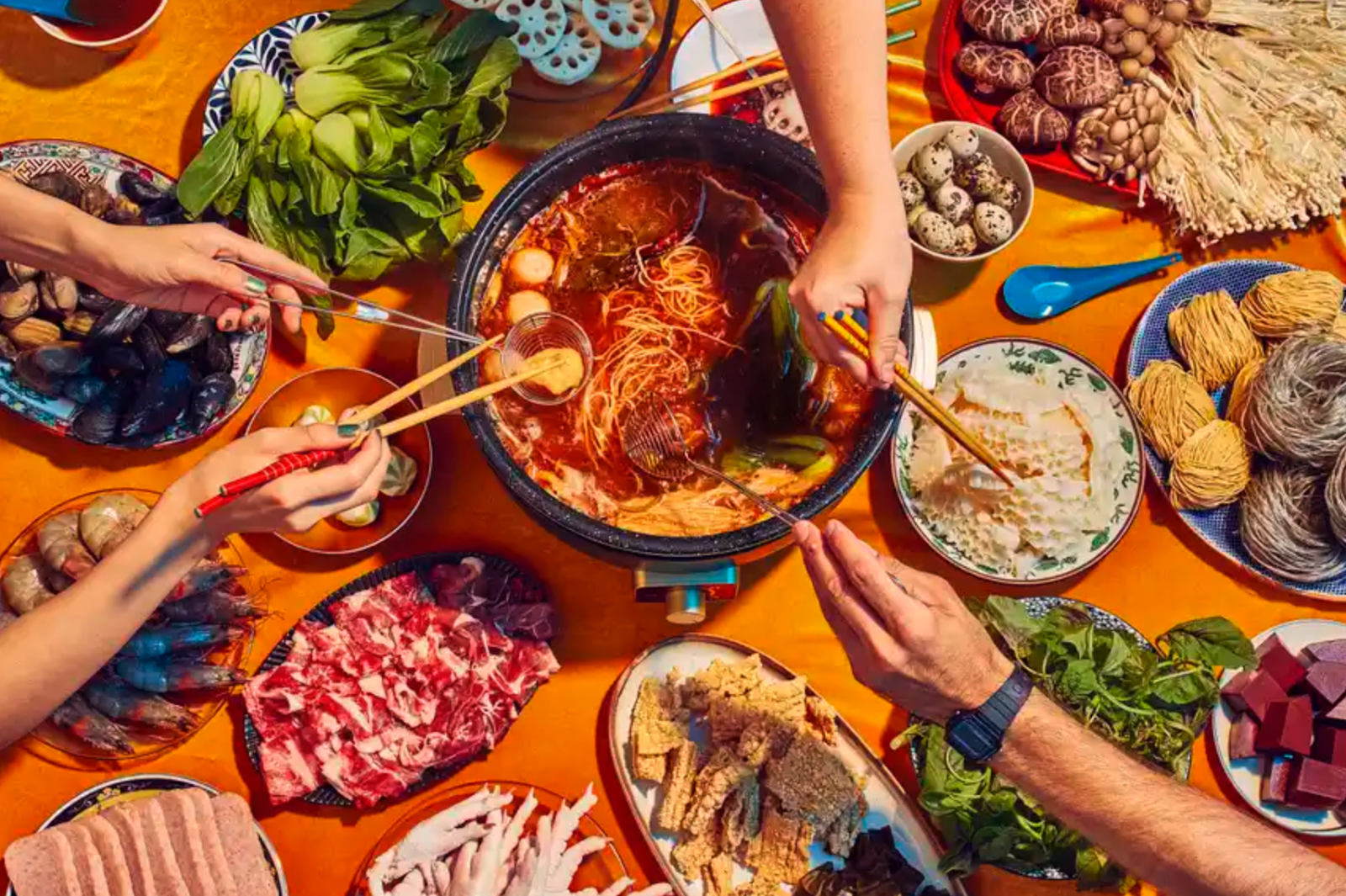 Fly by Jing’s photo of its hot pot in use shows an enticing meal spread out on a table.