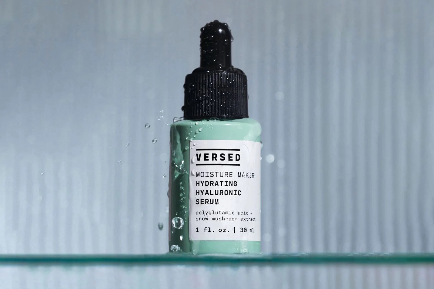 A bottle of skin serum by Versed skincare, covered in condensation