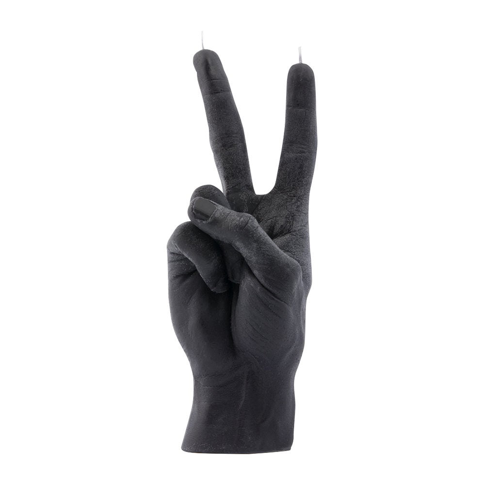 A black candle shaped like a hand doing a peace sign by candle business Amara
