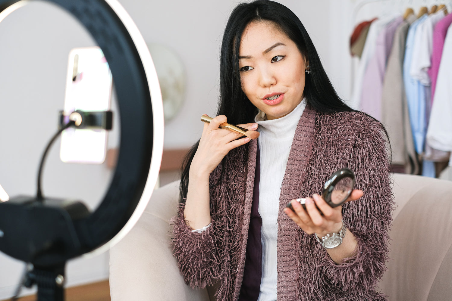 A woman in a blazer records herself for a YouTube video