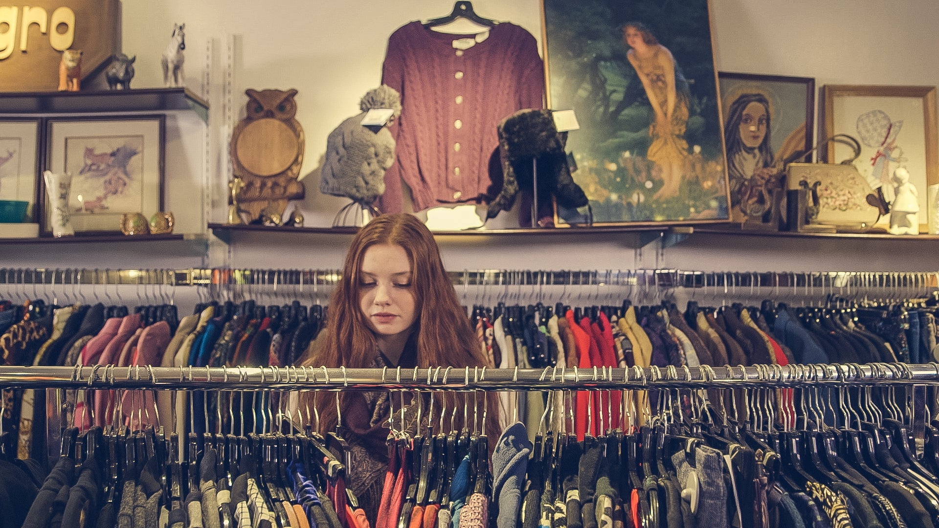 A person browses a clothing rack in a small boutique