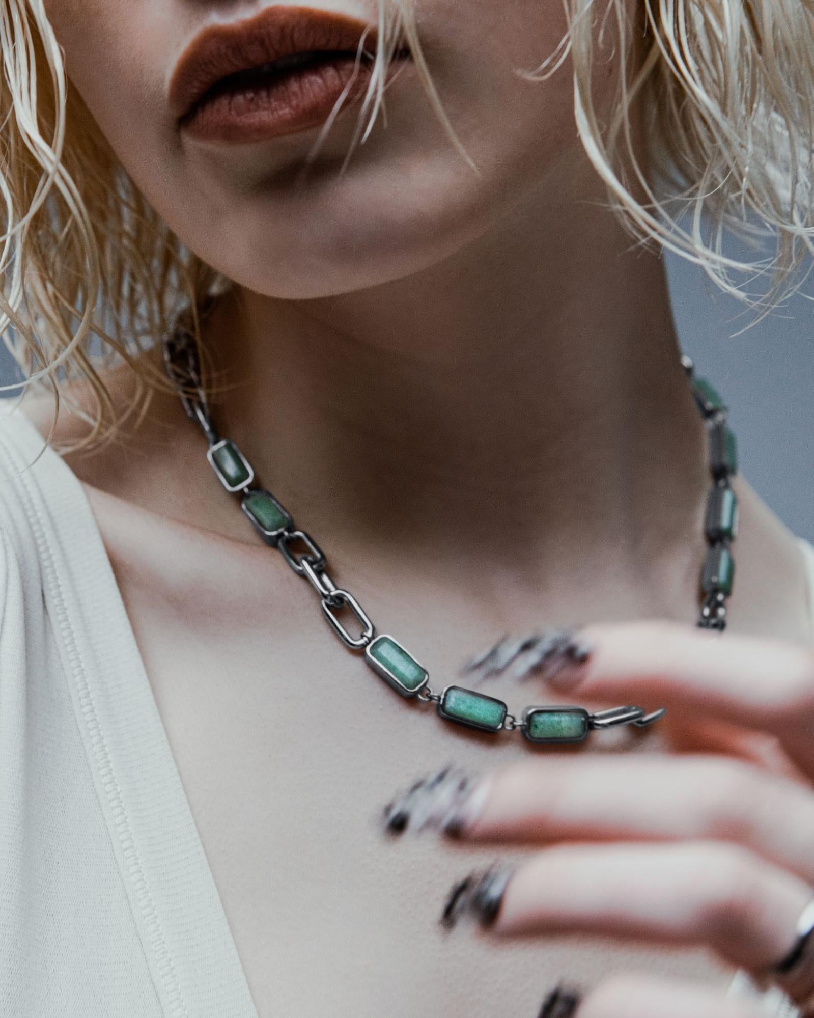 Bottom half of model’s face shown donning red lipstick with a Vitaly chain on their neck.