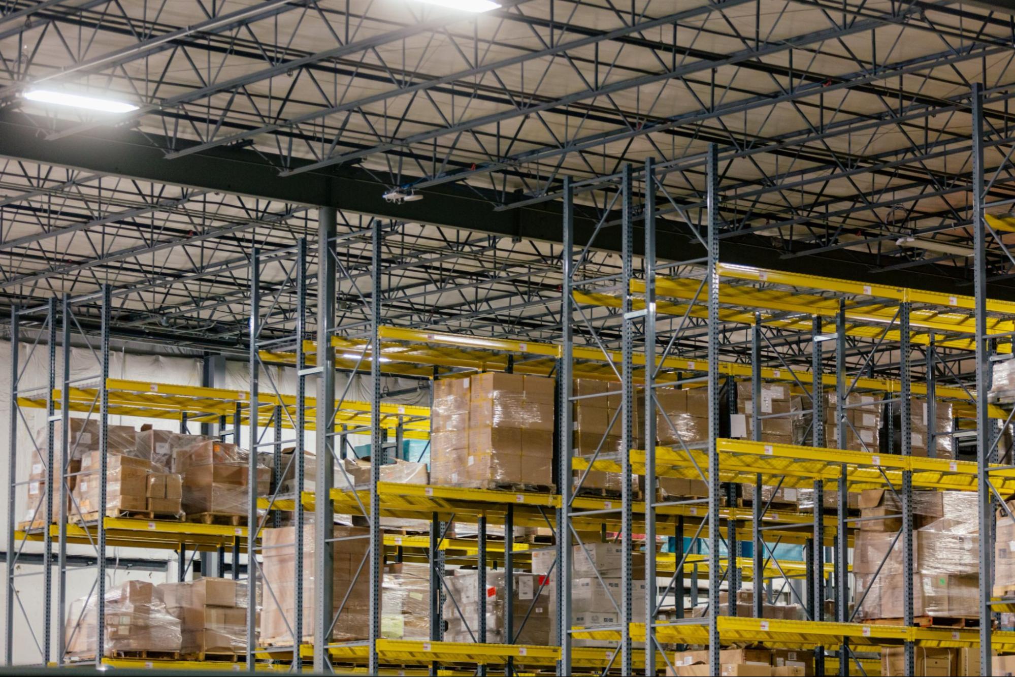 The gray and yellow warehouse shelving, mixed with overhead rafters, creates an interesting metal mesh.