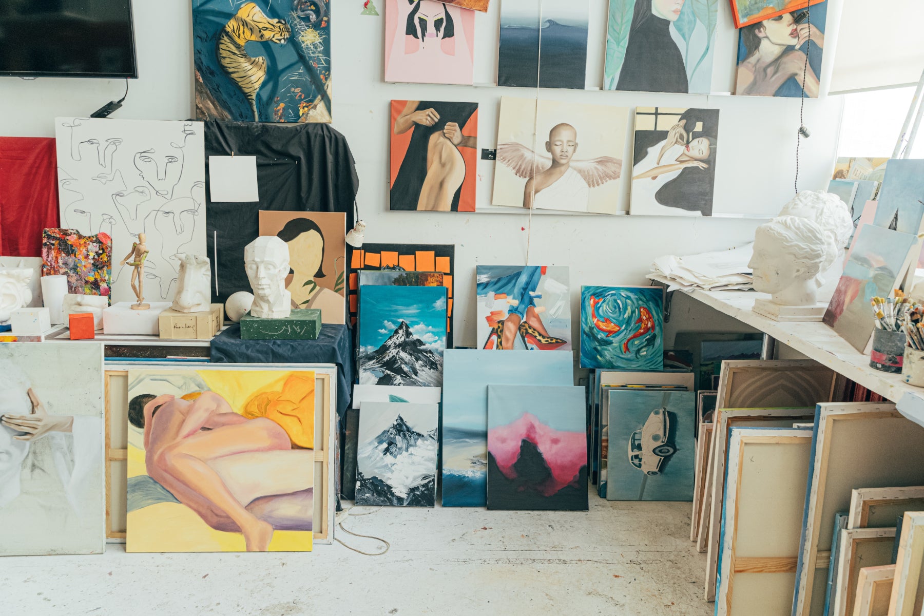 An art studio packed with painted canvases