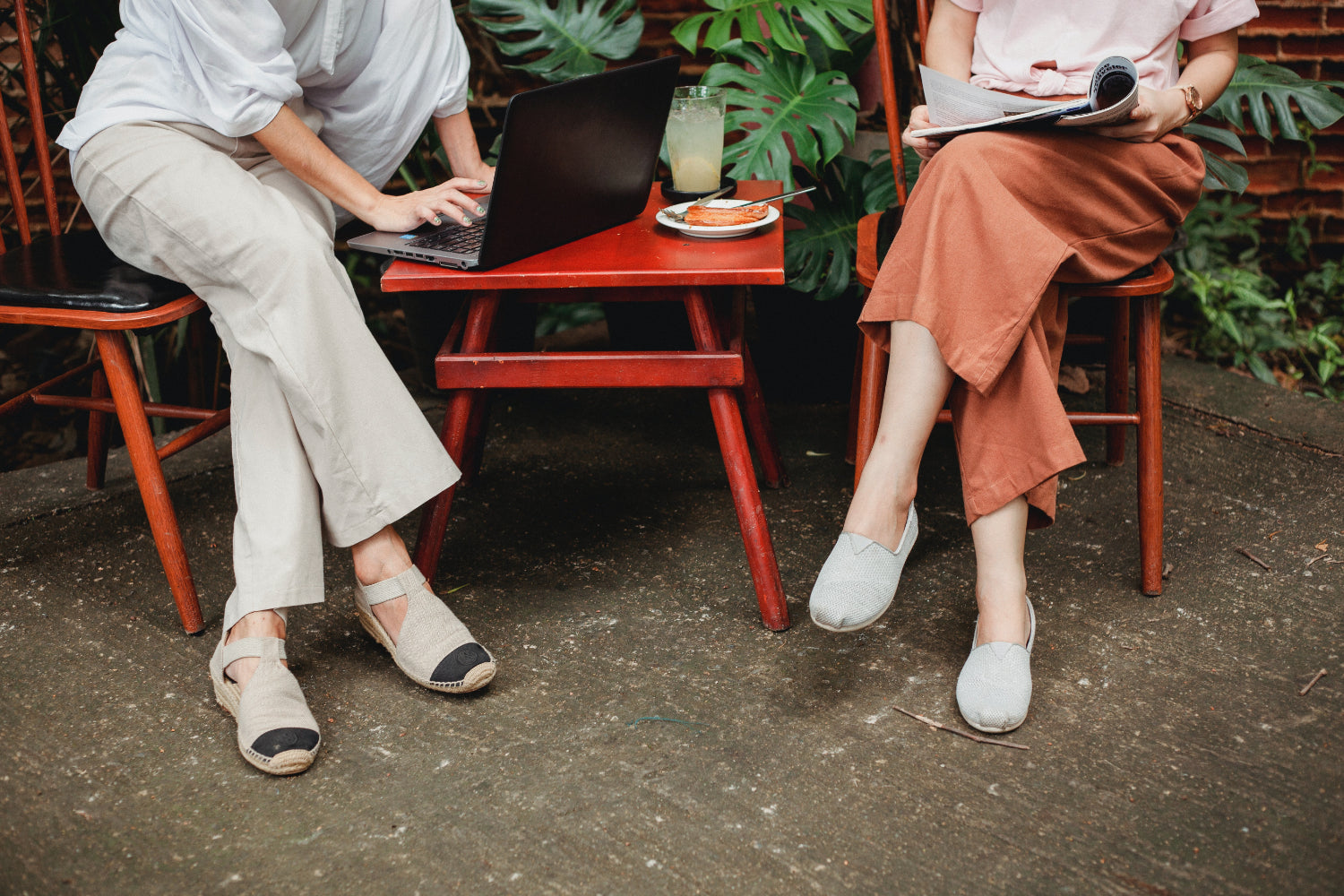 Two people sit at a cafe table outdoors