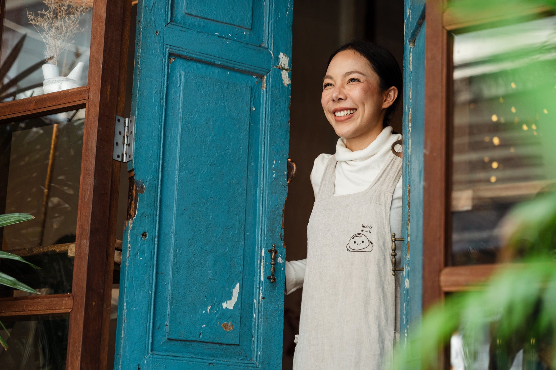 Woman peers out of a door of a retail shop