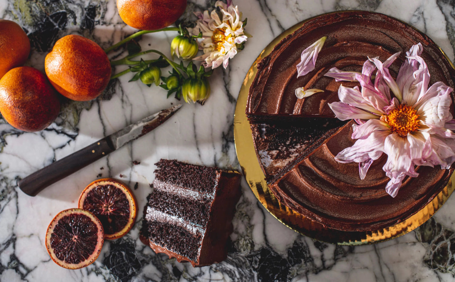 A spread of food and botanicals surrounding a cake