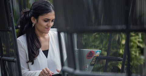 Woman working on laptop at outdoor table: Florida LLC