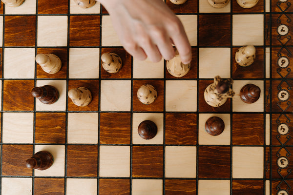 person moving a piece on a chess board to represent amazon seo strategy