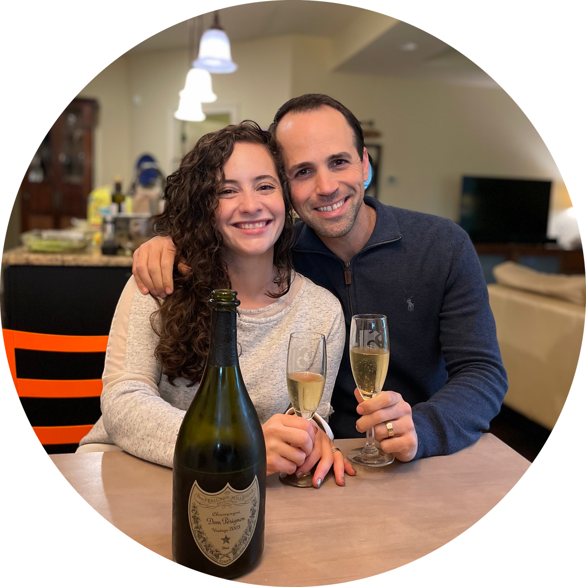 Image of co-founders Emma Schermer Tamir and Erez Tamir sit at a dinner table, posing for a photo with celebratory drinks.