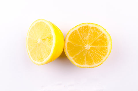 A lemon cut in half on a white background