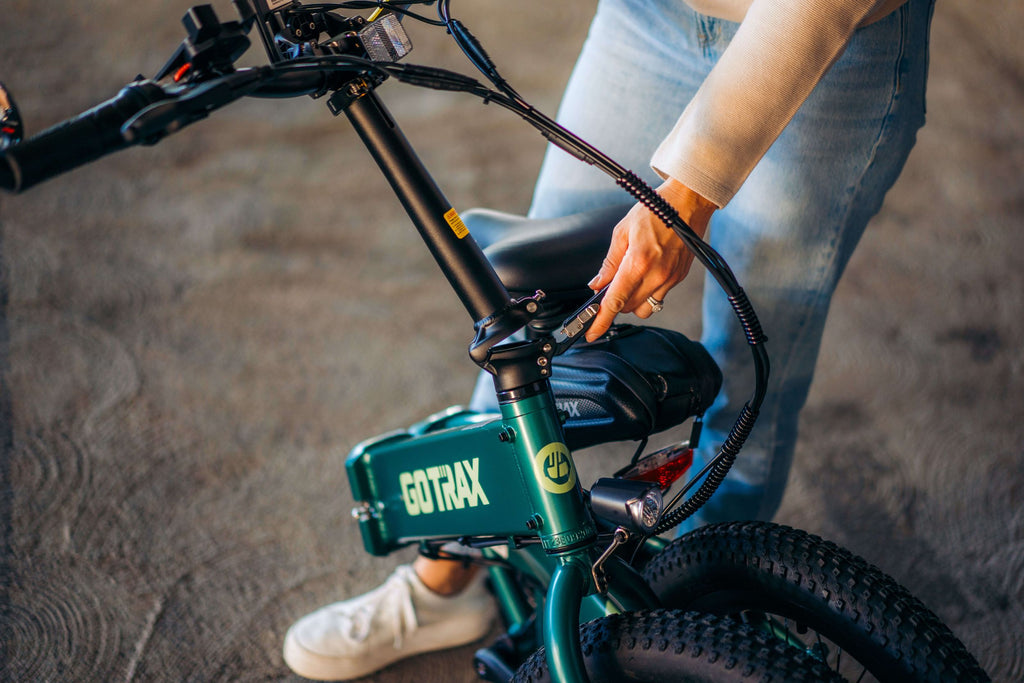 A woman folding the handlebars of the GOTRAX F1 Folding Electric Bike.