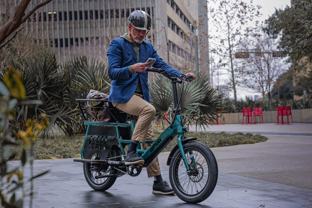 A man standing with the GOTRAX Porter Electric Cargo Bike with a 330 pound carrying capacity and optional kid carrier.