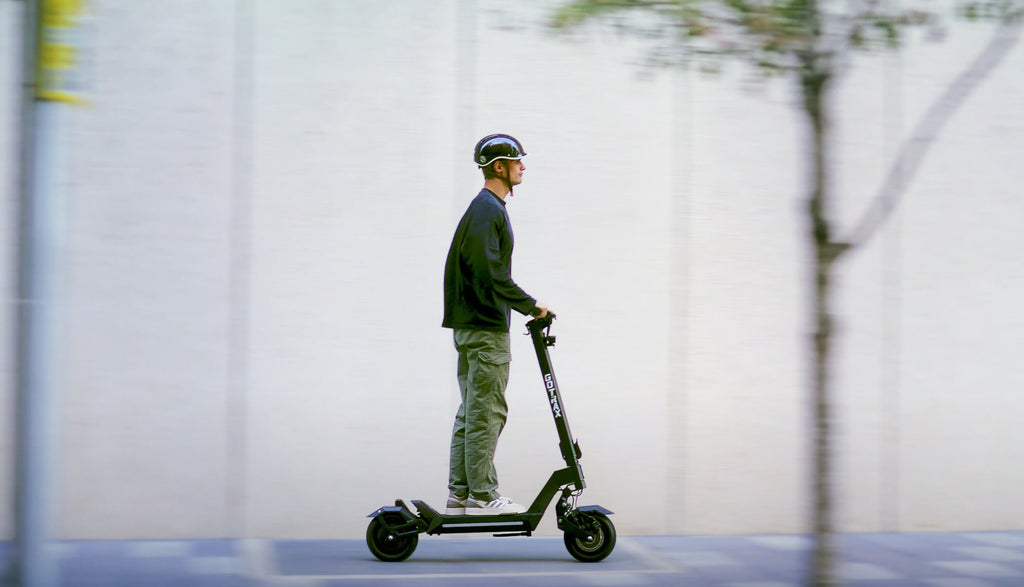 Person riding the GOTRAX GX1 Performance Electric Scooter on a Paved Path