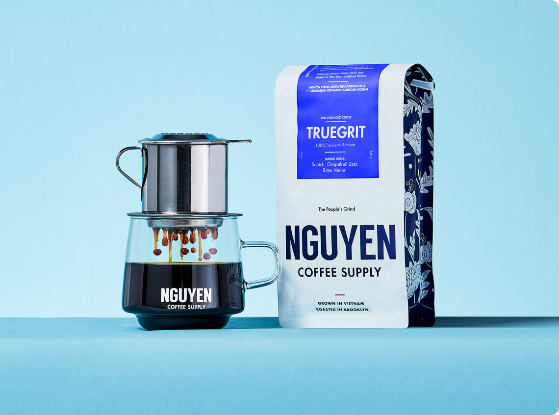 Vietnamese coffee drip brewing beside Truegrit Nguyen Coffee Supply package.