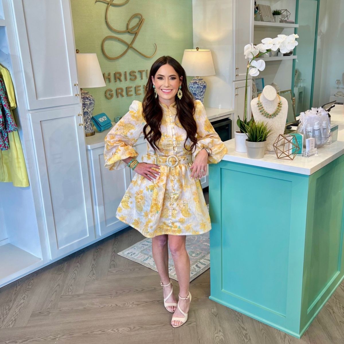 Christina Greene standing in front of the logo at her new Houston store.