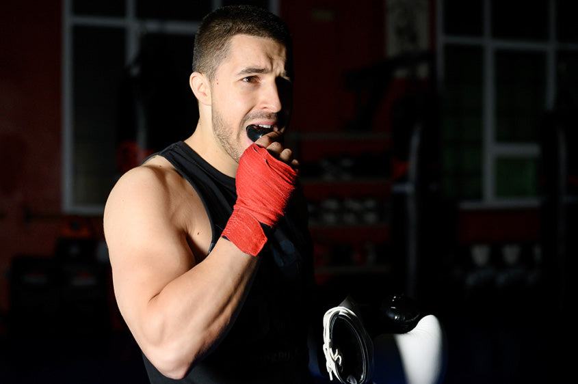 boxing fighter putting on a mouthguard