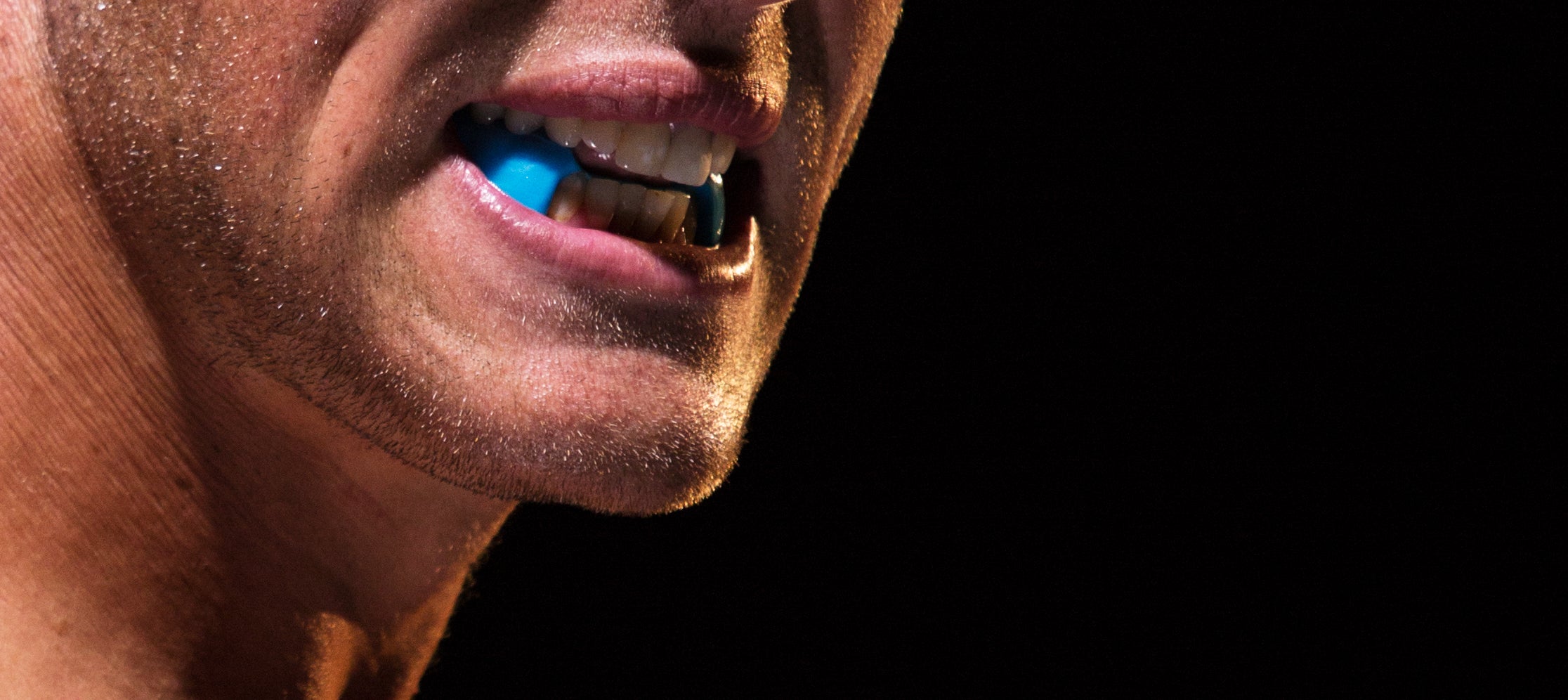 ARC Lower Performance mouthguard in blue shown on athlete's teeth closeup