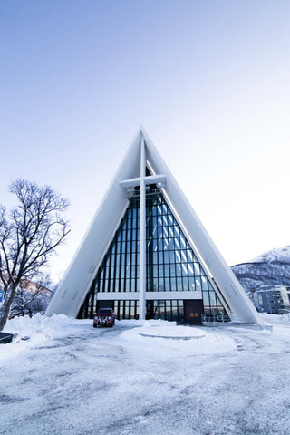 A bright crisp winter day sees a snowy ground in front of the white pointed Arctic Cathedral