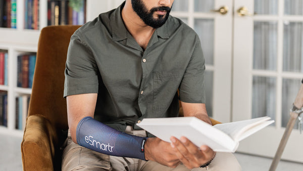 A man finds time to read a book with an eSmartr sleeve on his arm.