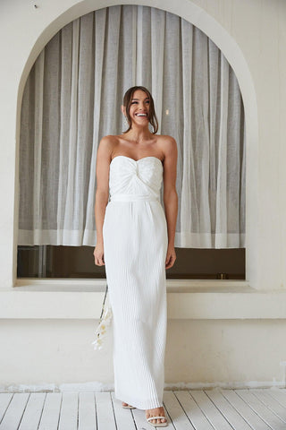 model wearing a white strapless sweetheart neckline twist bodice maxi flowy gown