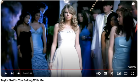 Taylor swift wearing a white strapless tube neck flowy a-line gown