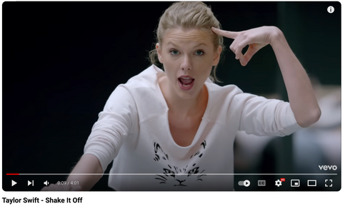 Taylor swift in shake it off music video wearing a white activewear top