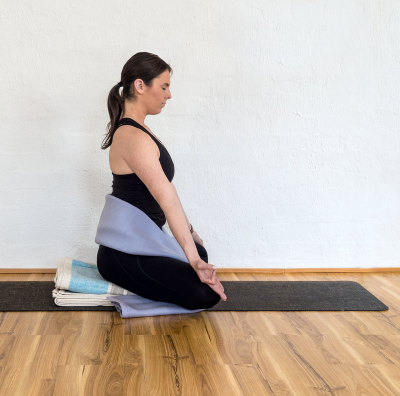 Wrapping a long-fold blanket around your lower back and torso, like a firm, wide belt. 