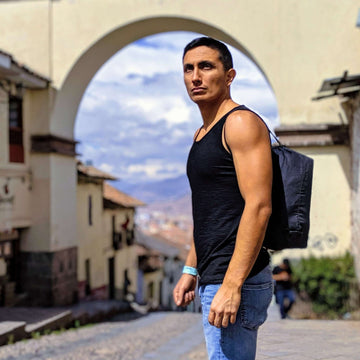 Man wearing black men's alpaca wool tank top in an archway