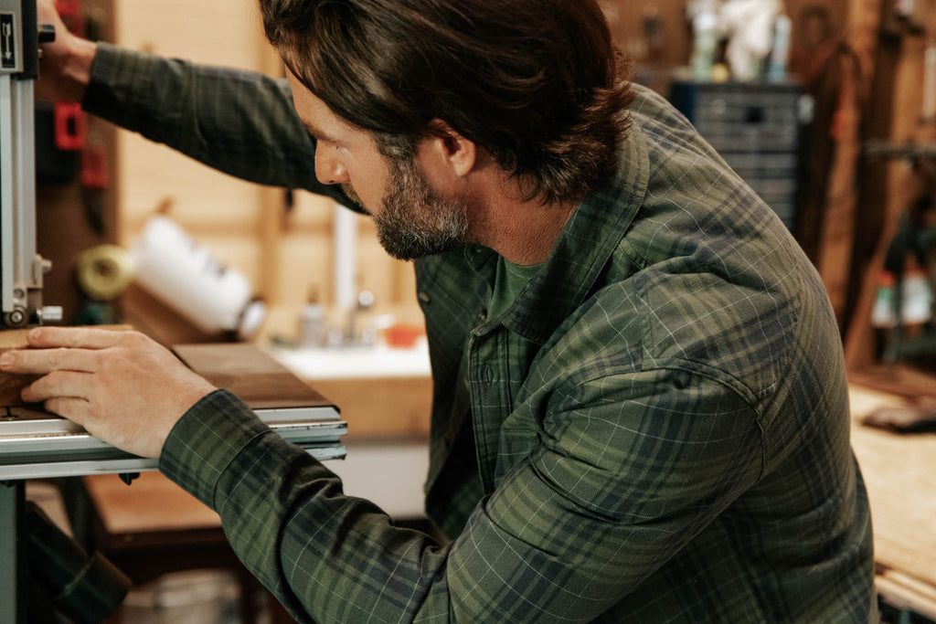 Man wearing park flannel working in the wood shop