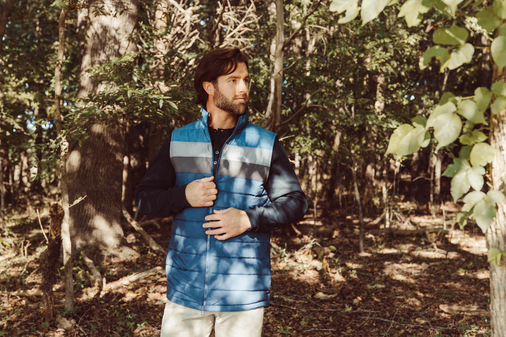 Man wearing rider vest walking in the woods