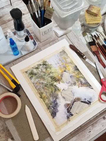 An artwork in progress where I work at my painting table.  Watercolor painting of a waterfall.